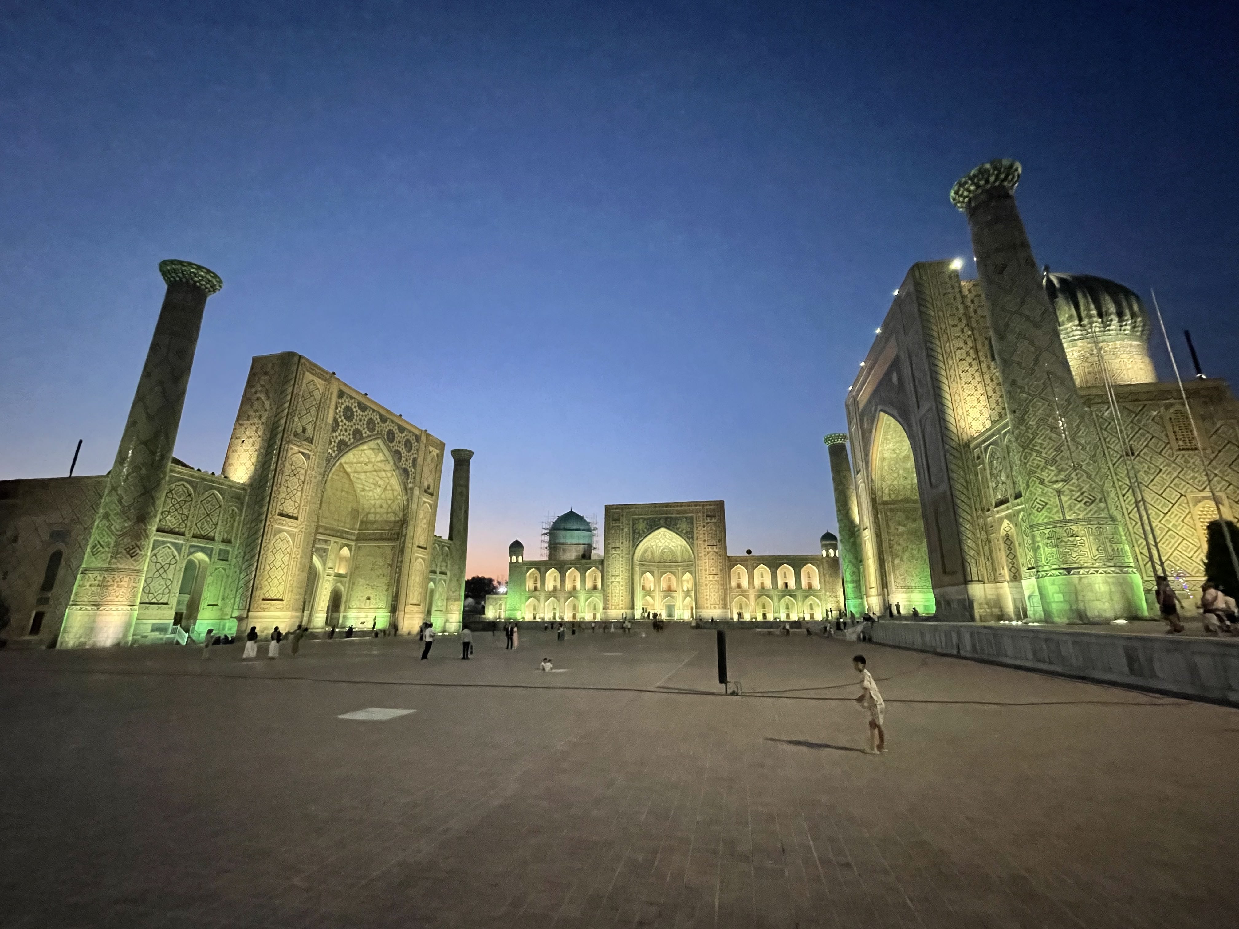 Registan Square in Samarkand, Uzbekistan, its three madrasas lit up at dusk